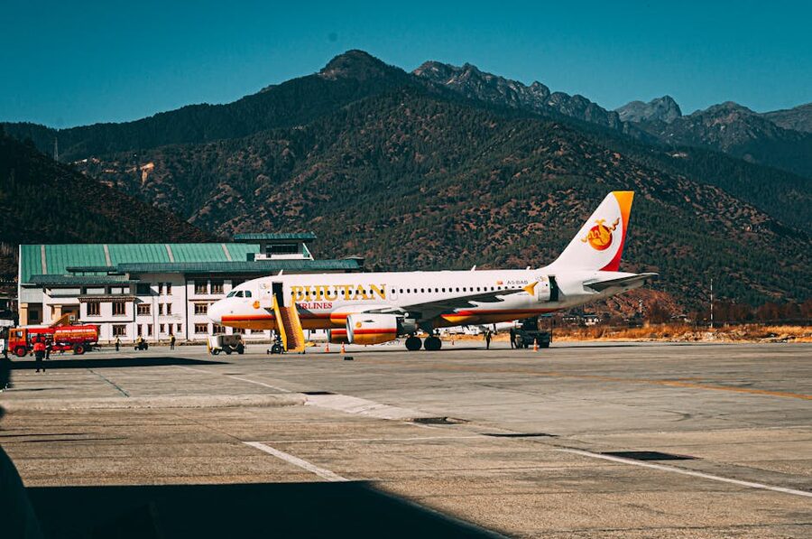Bhutan Airlines aircraft at Paro Airport with mountain backdrop