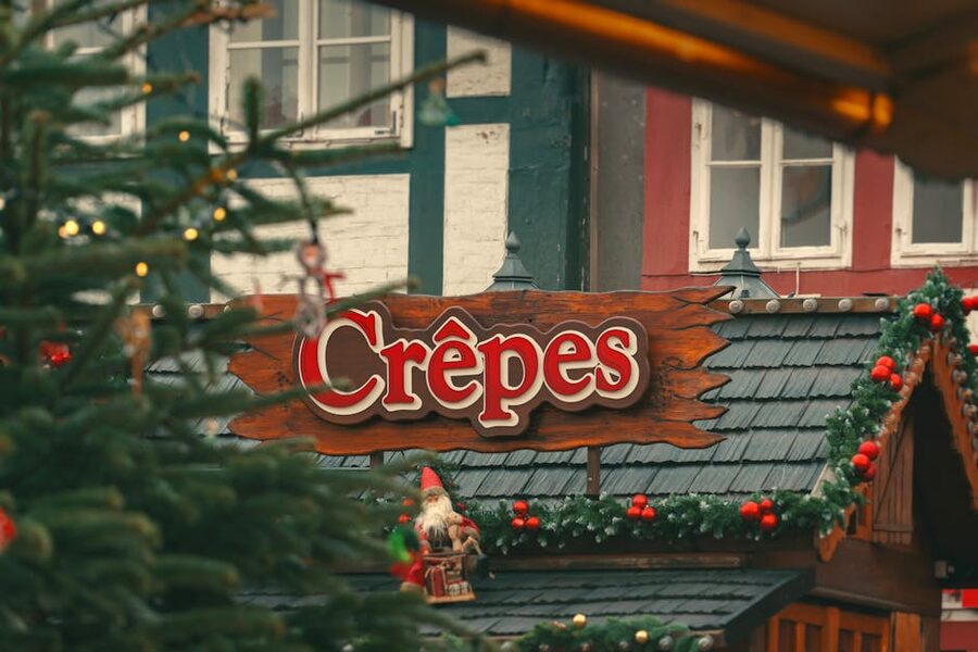 Christmas market crêpes stall with garlands and warm lights