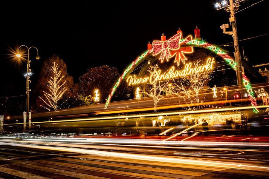 Vienna Christmas market lights at night with crowds and ornament stalls
