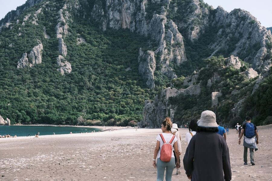 People walking along Cirali Beach with picturesque mountains, Antalya