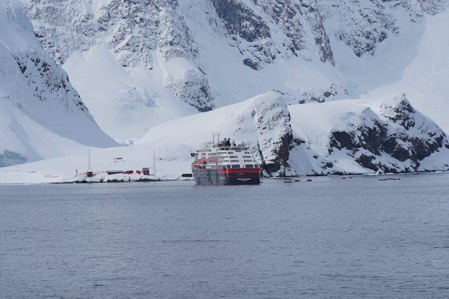 A small expedition cruise ship navigating between icebergs