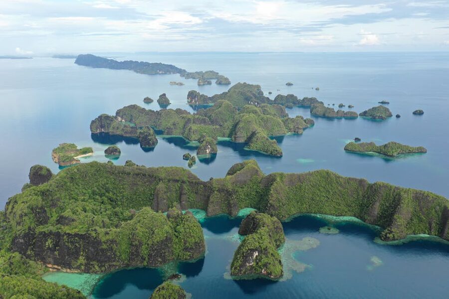 Aerial view of the lush green islands and turquoise water of Raja Ampat, Indonesia