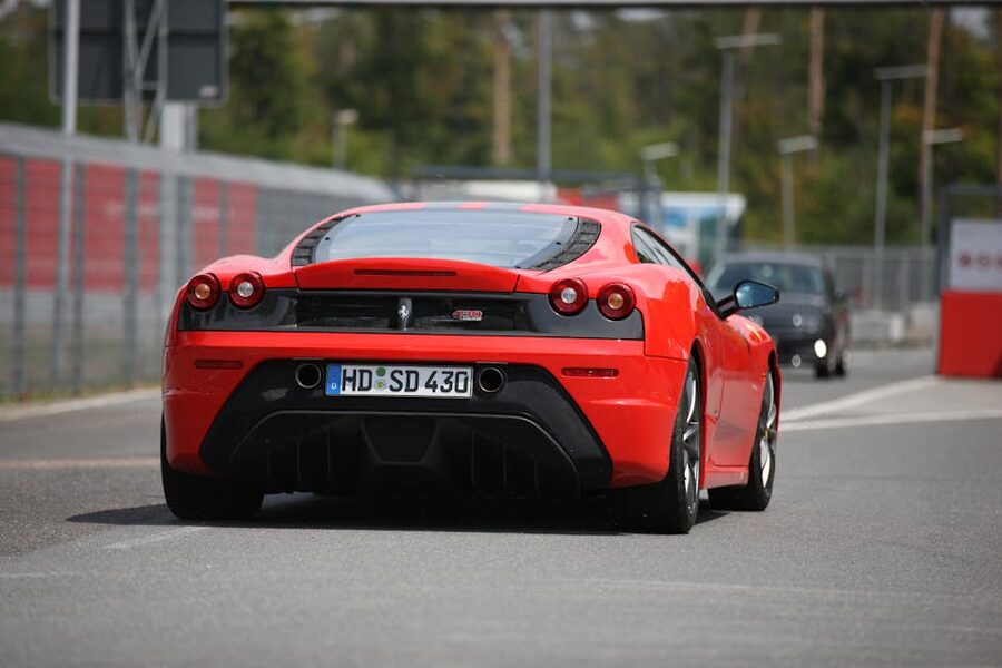 A red Ferrari sports car driving on a road