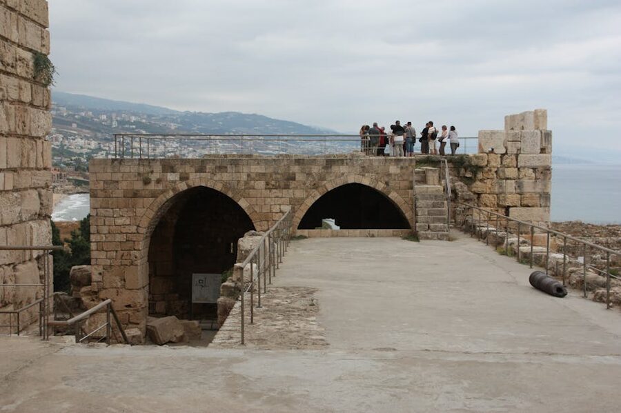 Visitors exploring Byblos Castle ruins overlooking the Mediterranean