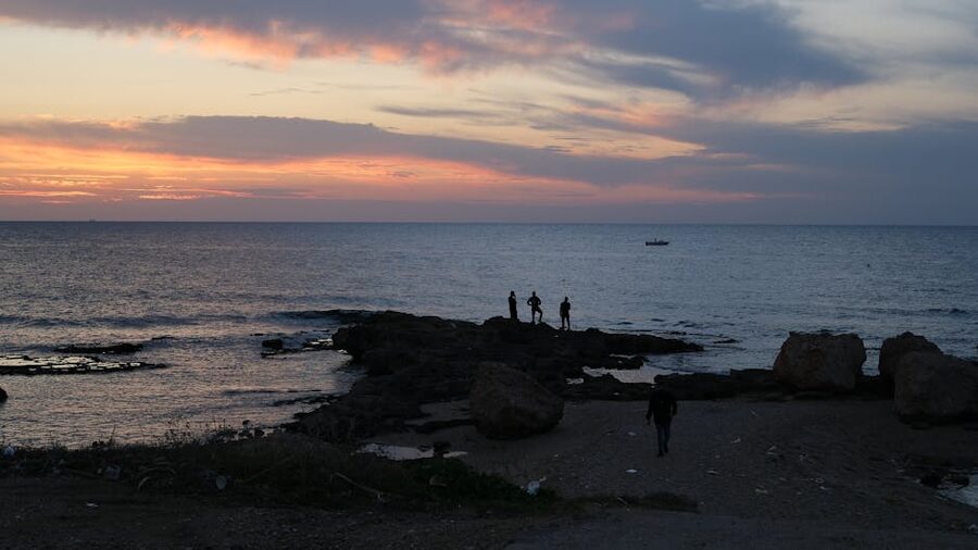 Fishermen at sunset on the Mediterranean coast in Tyre, Lebanon