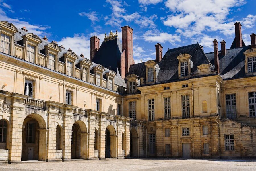 The exterior of Chateau de Fontainebleau under a clear blue sky