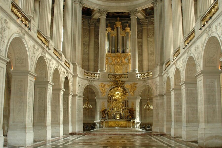 The Royal Chapel at the Palace of Versailles, with white marble columns and a vaulted ceiling