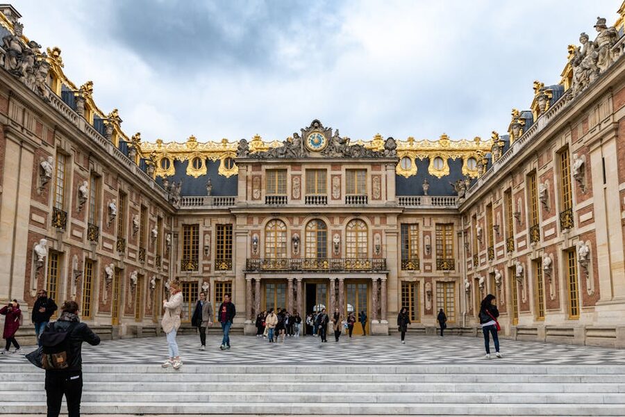 Visitors crossing the Cour d'Honneur courtyard at the Palace of Versailles