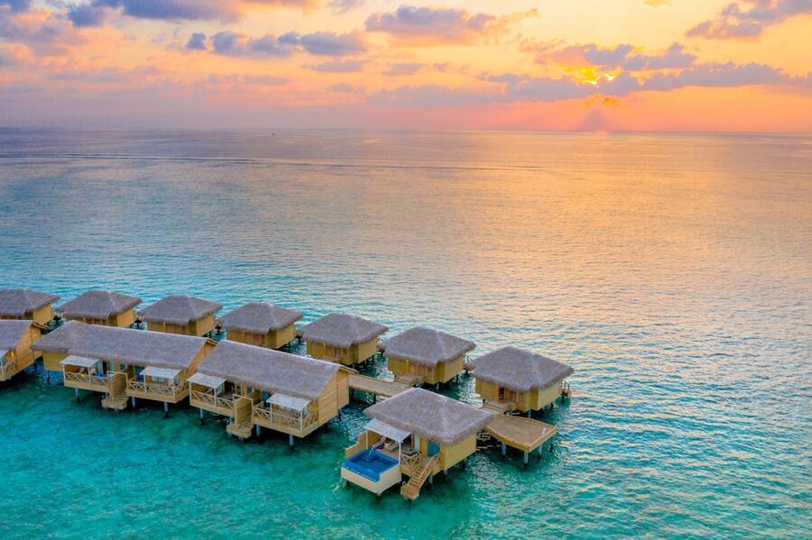 Aerial view of overwater villas in the Maldives at sunset