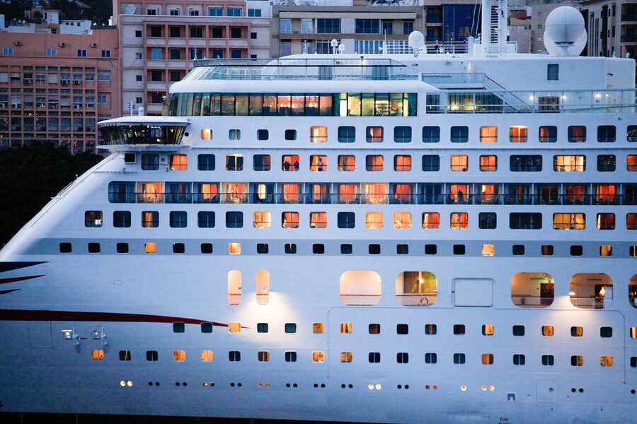 The exterior of a cruise ship showing tiered cabin balconies with sea behind