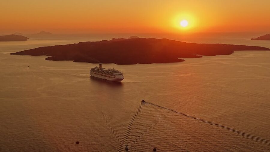 A cruise ship at sunset off Santorini, Greece