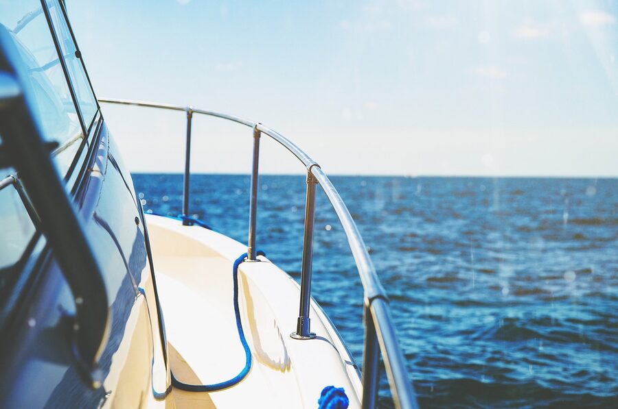 A teak yacht deck looking out over open ocean from the rail