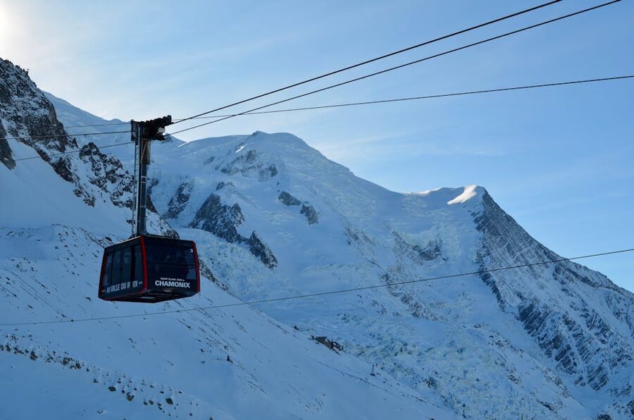 Aiguille du Midi cable car ascending with Mont Blanc backdrop in Chamonix