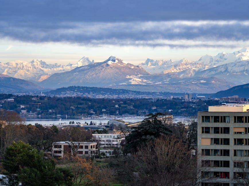 Geneva skyline with Swiss Alps backdrop on a partly cloudy day