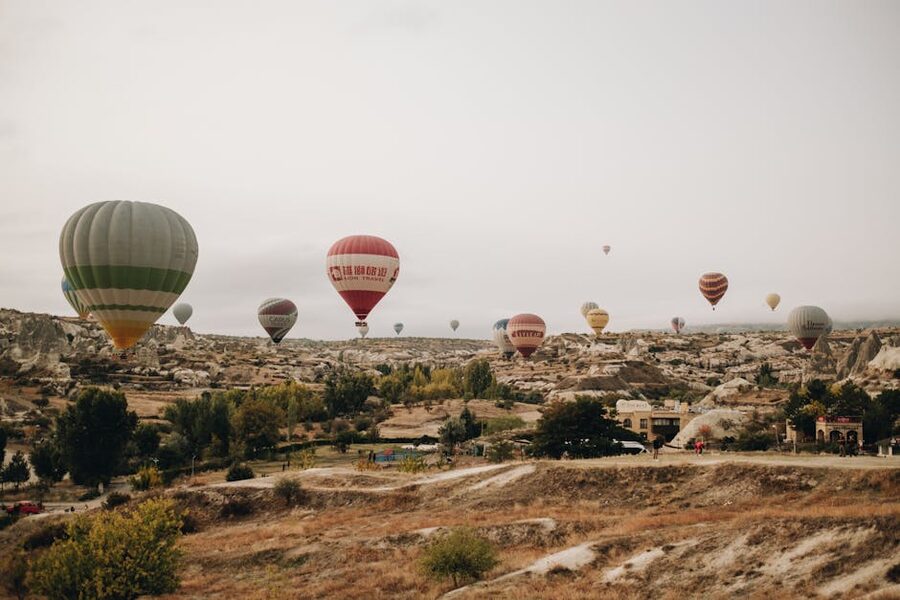 Fleet of colorful hot air balloons over Cappadocia rock formations