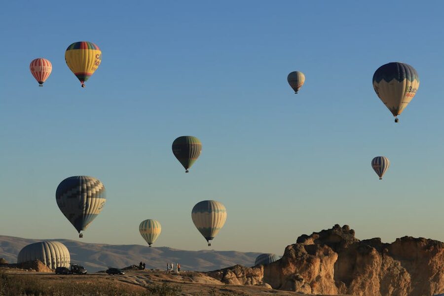 Hot air balloons rising at sunrise over Cappadocia fairy chimneys