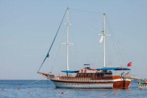 Wooden two-masted Turkish gulet anchored in clear Mediterranean water